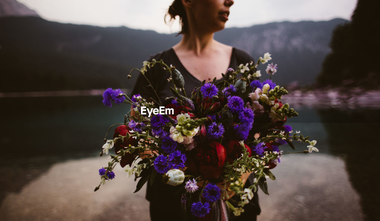 CLOSE-UP OF WOMAN STANDING ON PURPLE FLOWER