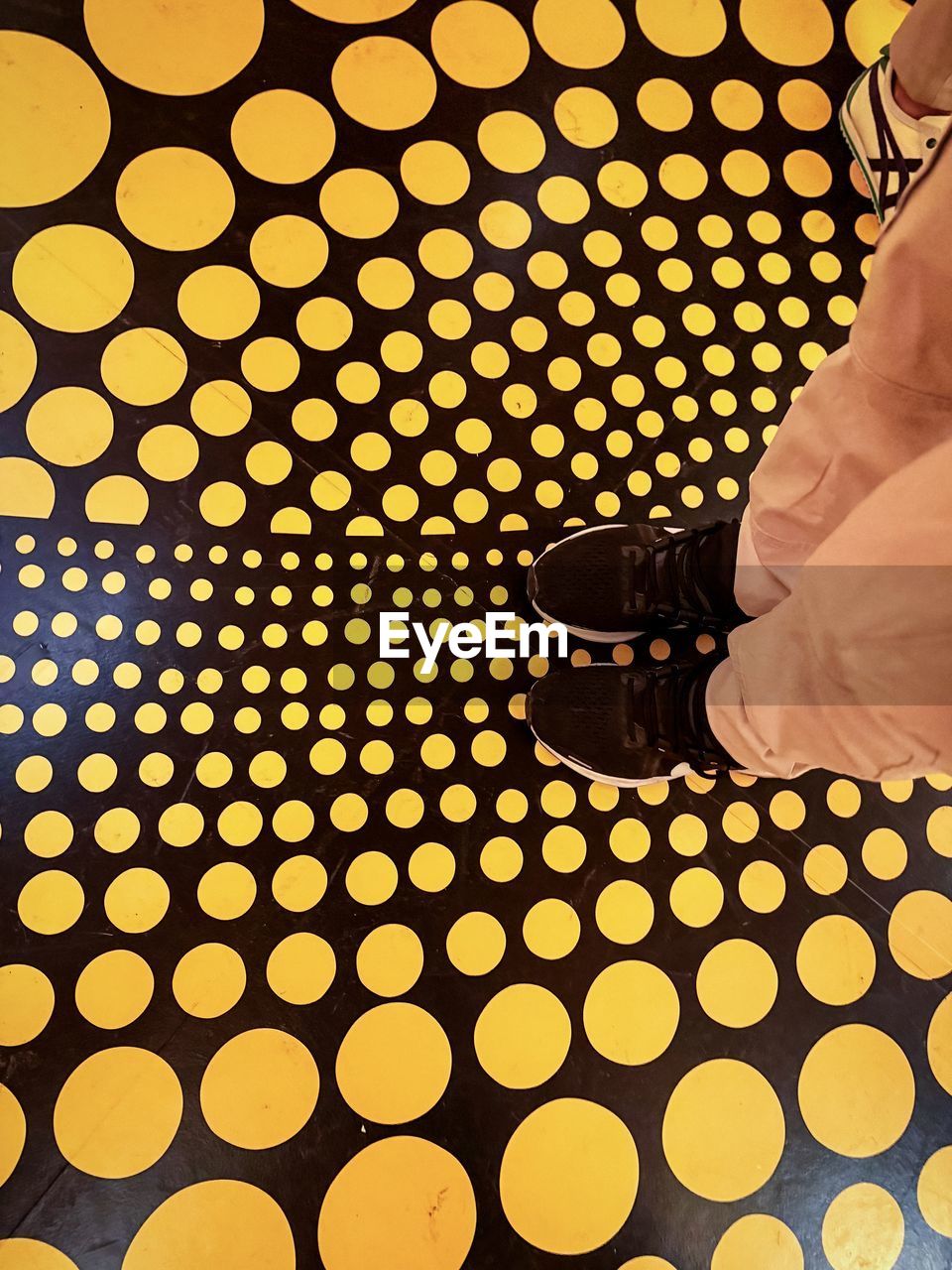 yellow, pattern, one person, circle, adult, geometric shape, indoors, shape, men, clothing, polka dot, shoe, lifestyles, leisure activity, low section