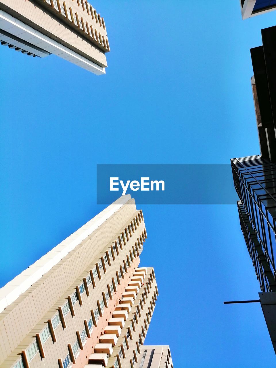 Low angle view of buildings against clear blue sky