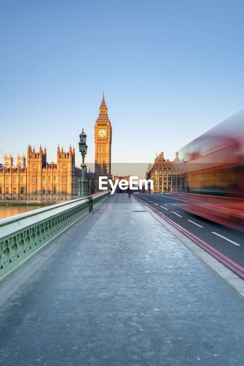 Double-decker bus passes on westminster bridge, in front of westminster palace and clock tower of big ben (elizabeth tower), london, england, united kingdom