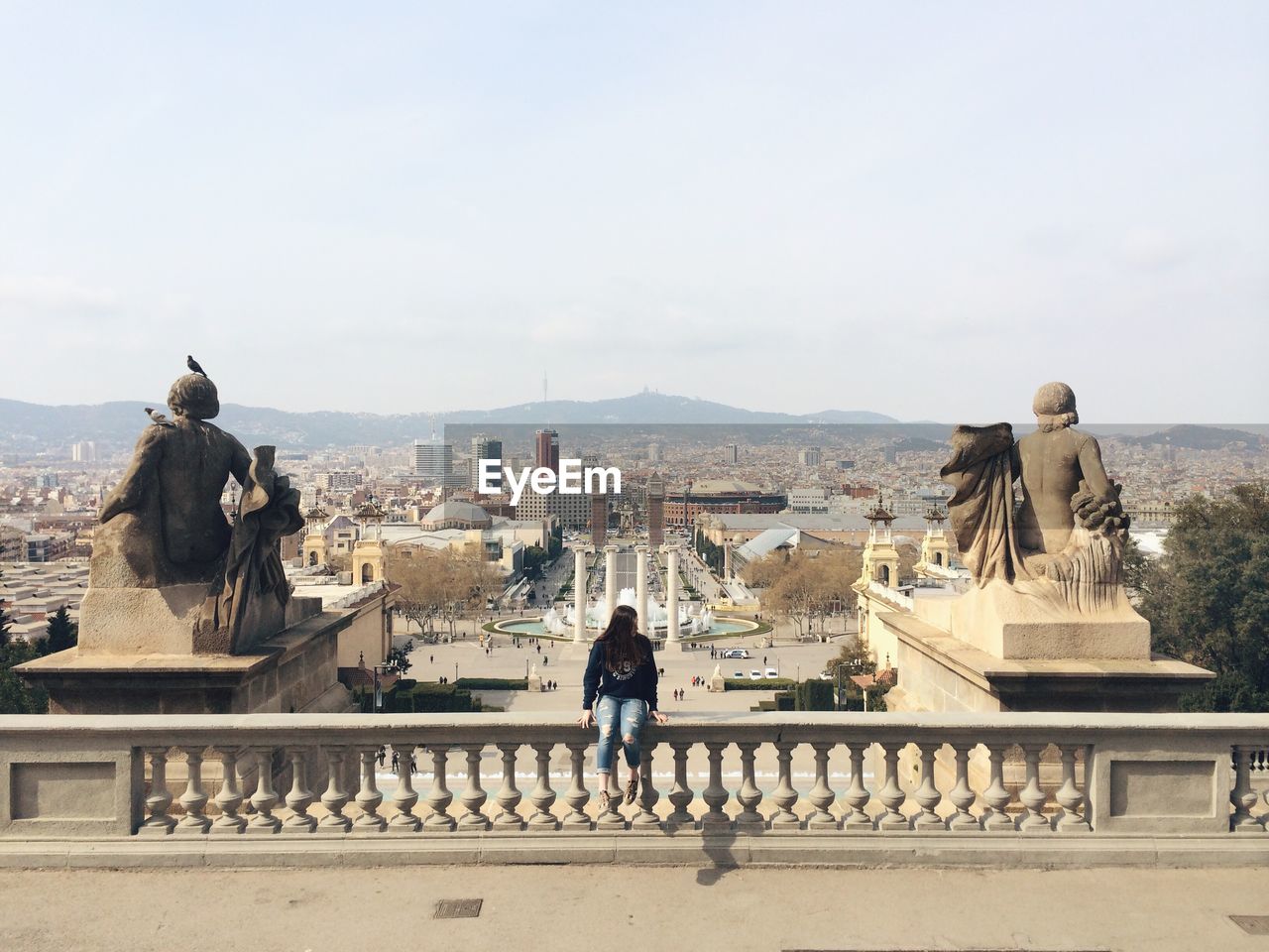 Woman sitting on railing at museu nacional d art de catalunya