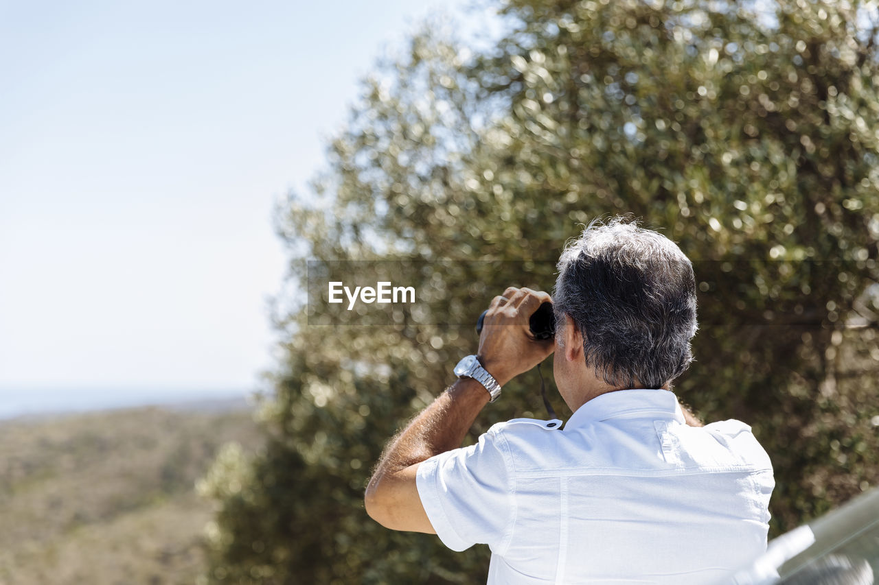 REAR VIEW OF MAN PHOTOGRAPHING