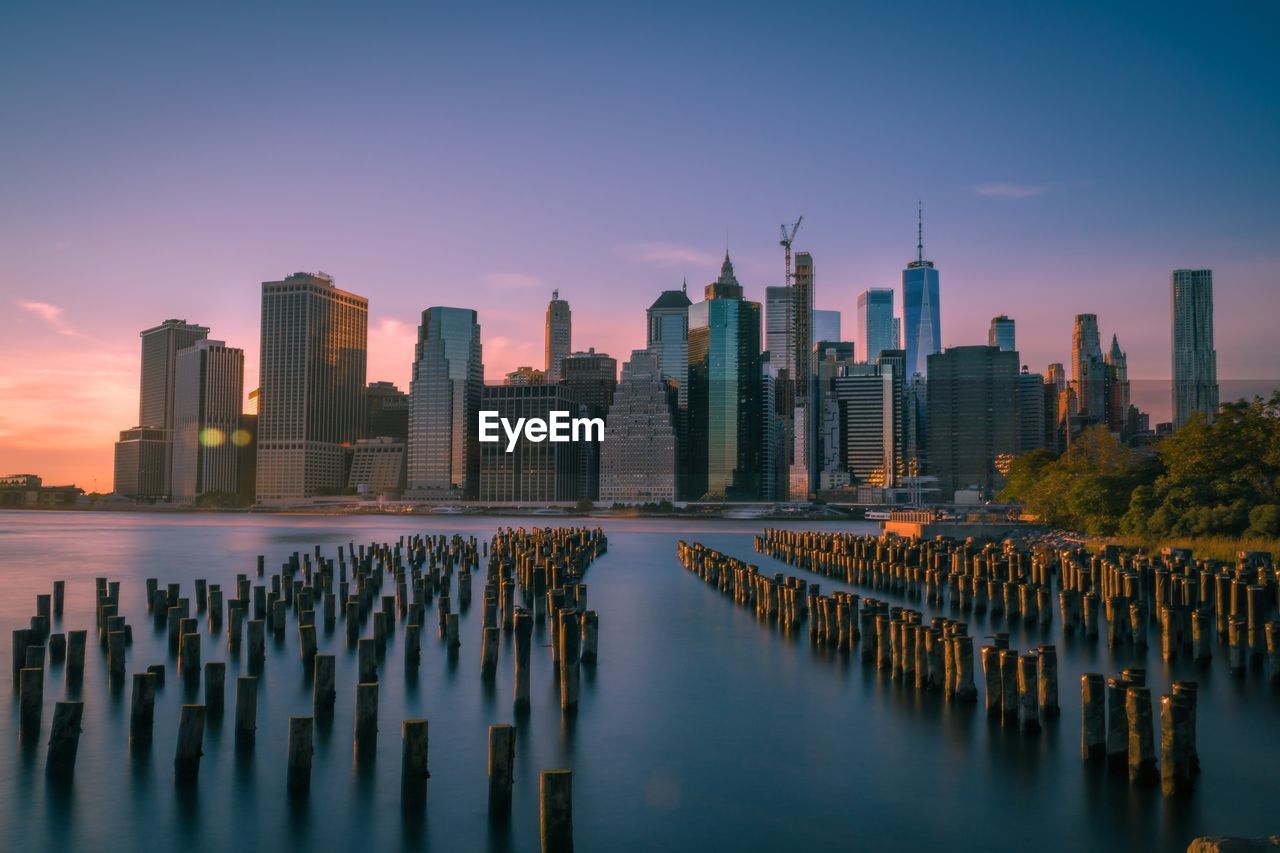 Panoramic view of sea and buildings against sky during sunset