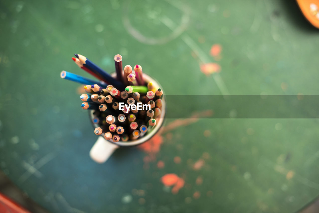 Close-up of colorful pencils in container on table