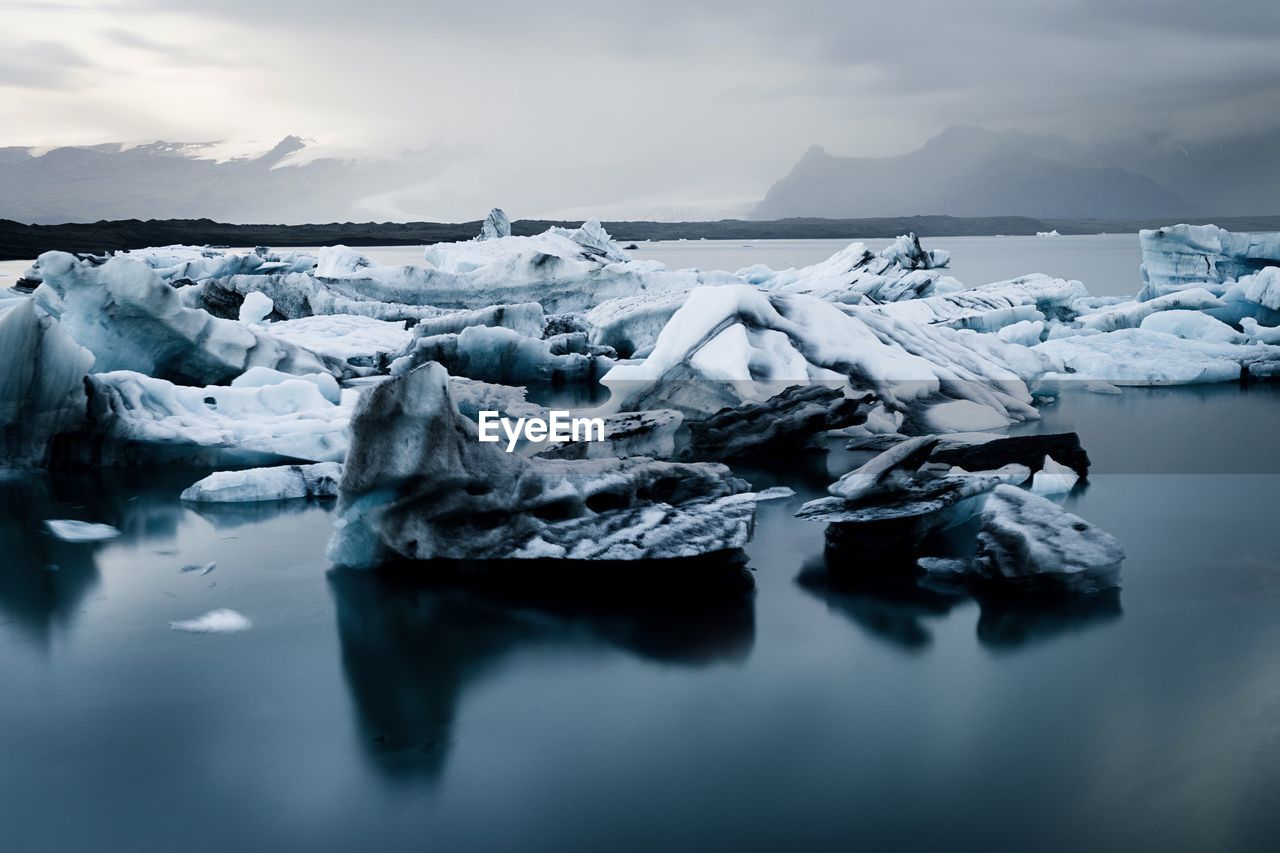 Frozen lake against sky during winter