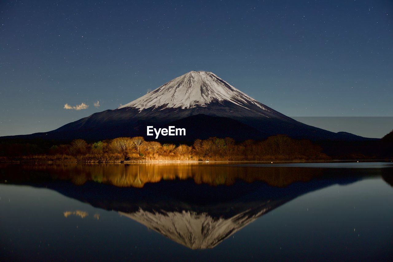 Scenic view of mt fuji reflecting on lake against clear sky