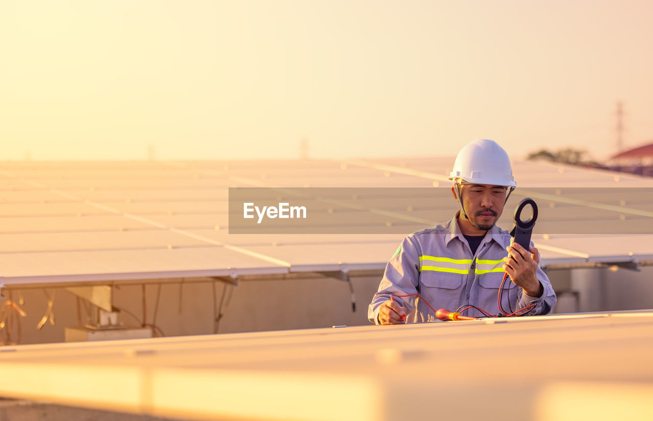 Engineer inspects solar panels on roof of modern house. alternative energy ecological concept.