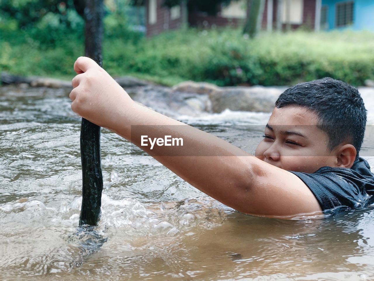 Boy catching fish while swimming in river