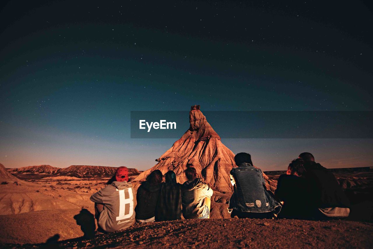 LOW ANGLE VIEW OF PEOPLE ON DESERT AGAINST SKY