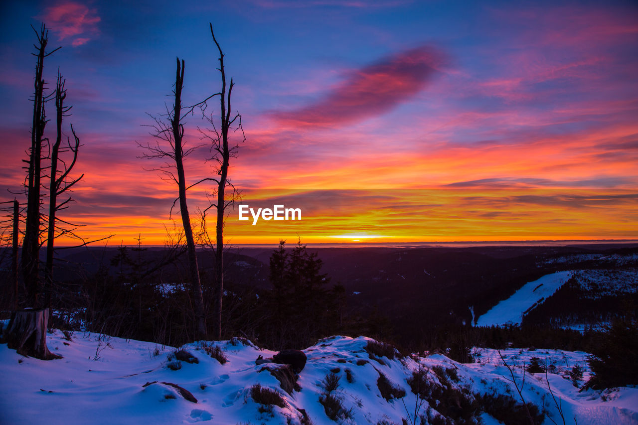 Scenic view of snow covered landscape against sky during sunset