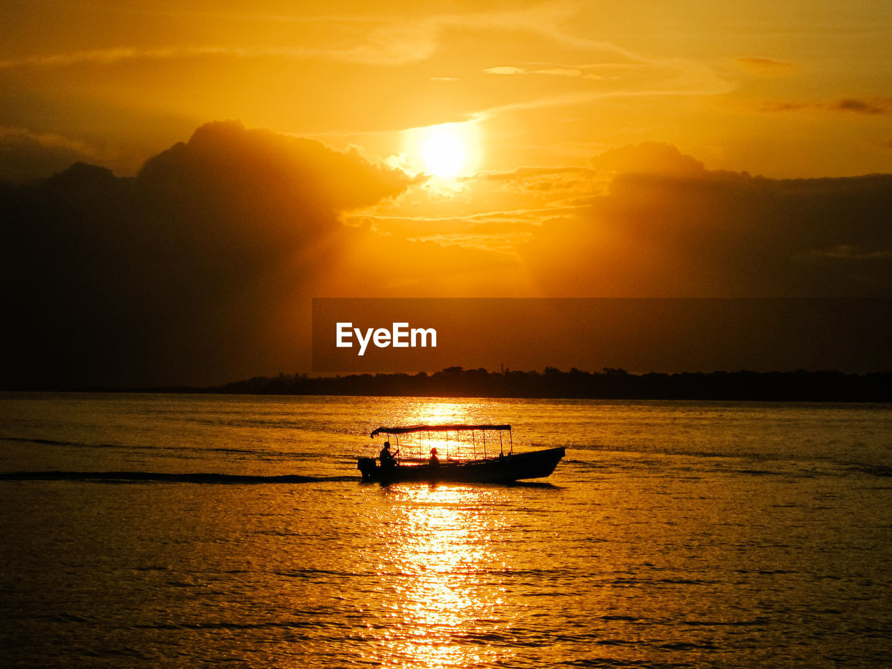 Silhouette boat sailing on sea against sky during sunset