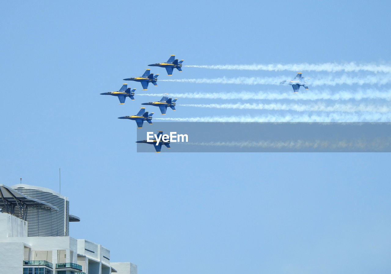 Low angle view of airshow against sky