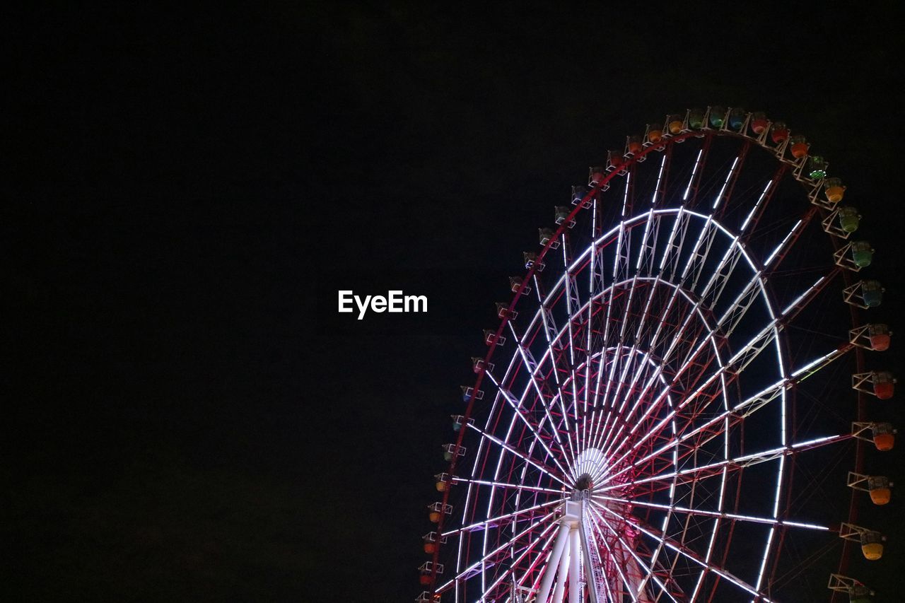 Low angle view of illuminated ferris wheel against sky at night