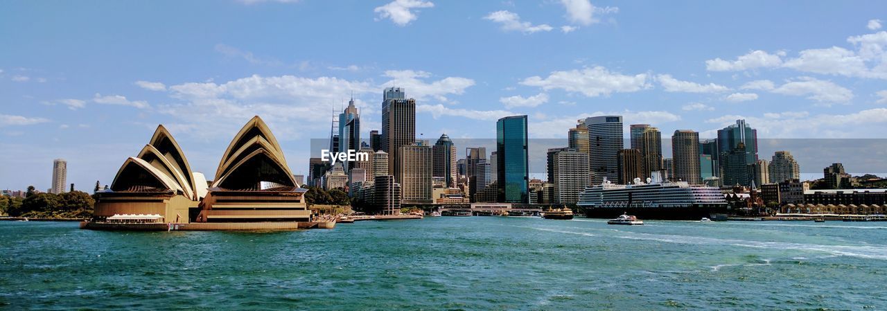 Buildings at waterfront against sky