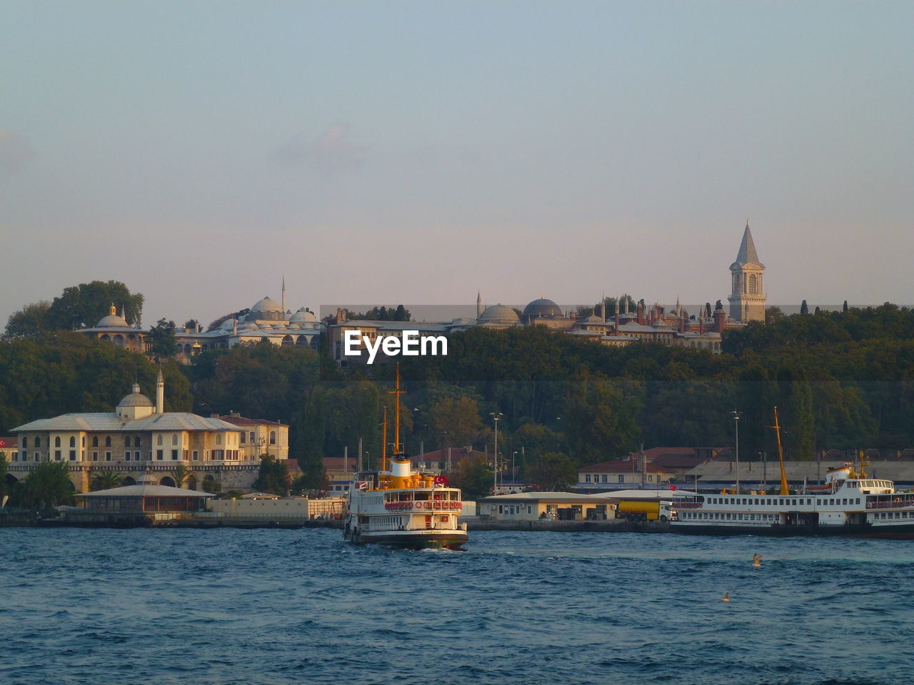 Boats in sea by buildings in istanbul against sky