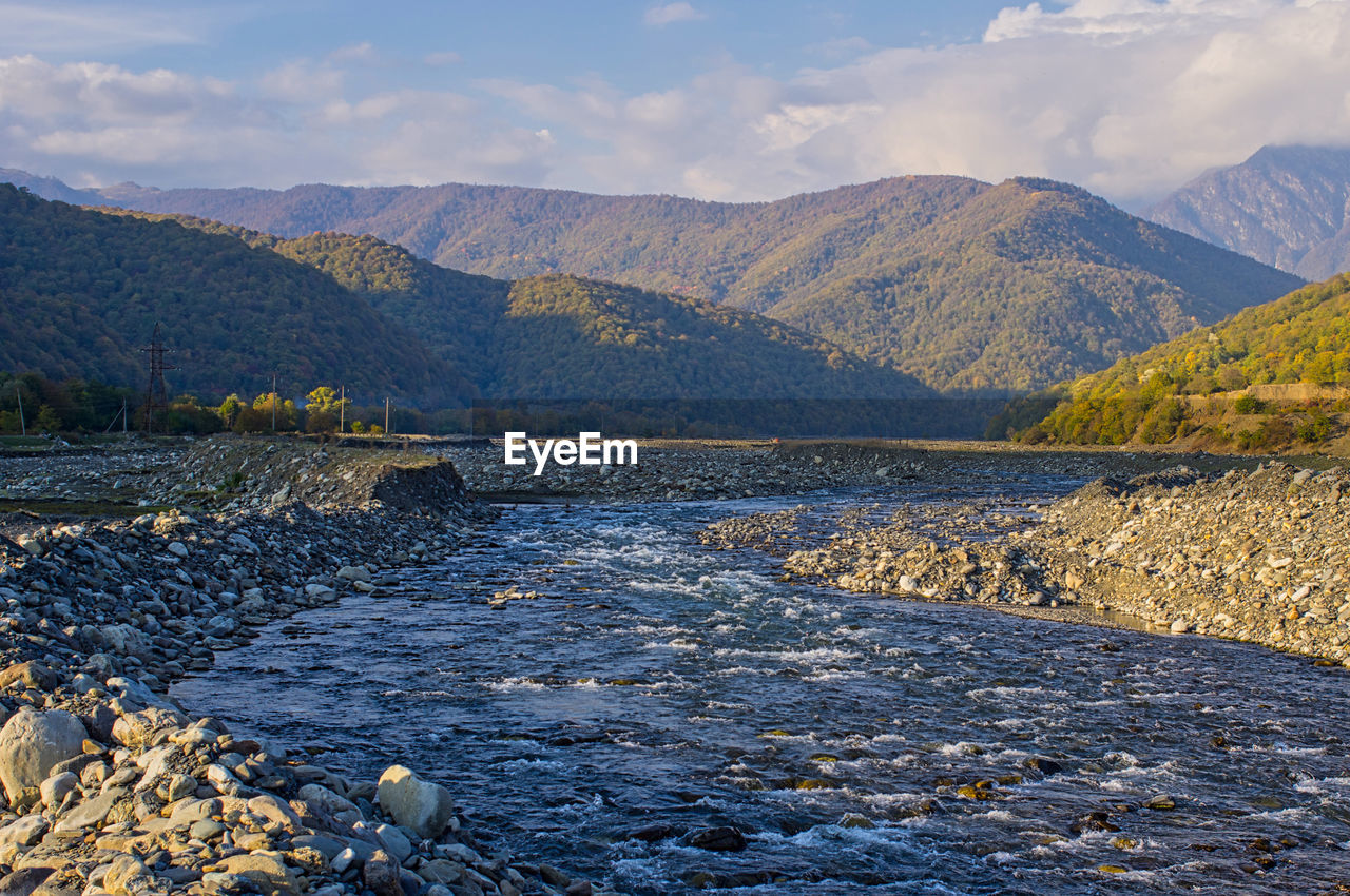 Scenic view of lake by mountains against sky