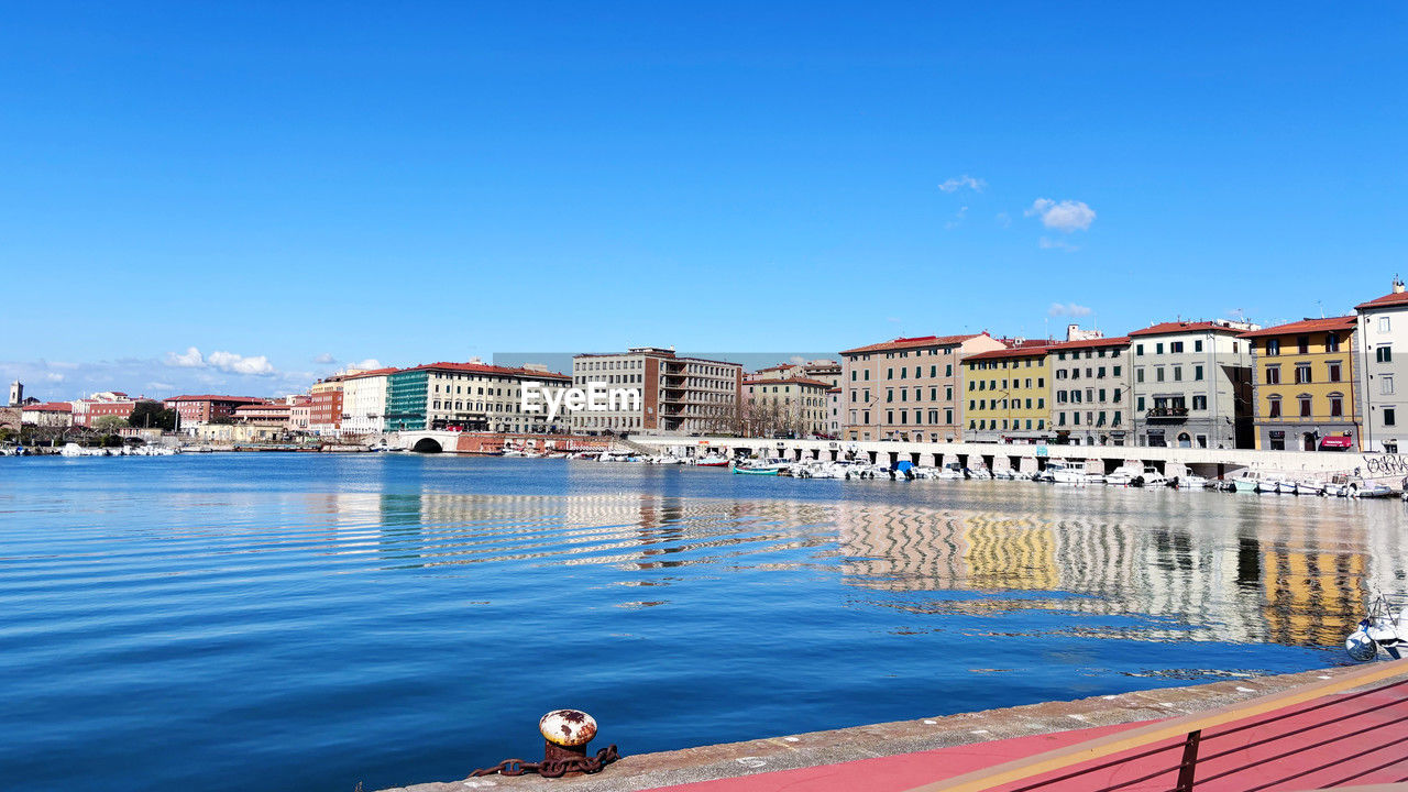 water, architecture, built structure, building exterior, sky, sea, nature, blue, city, swimming pool, clear sky, dock, building, vacation, travel destinations, day, no people, marina, reflection, sunny, outdoors, nautical vessel, residential district, cityscape, travel, transportation, pier, sunlight, harbor, copy space