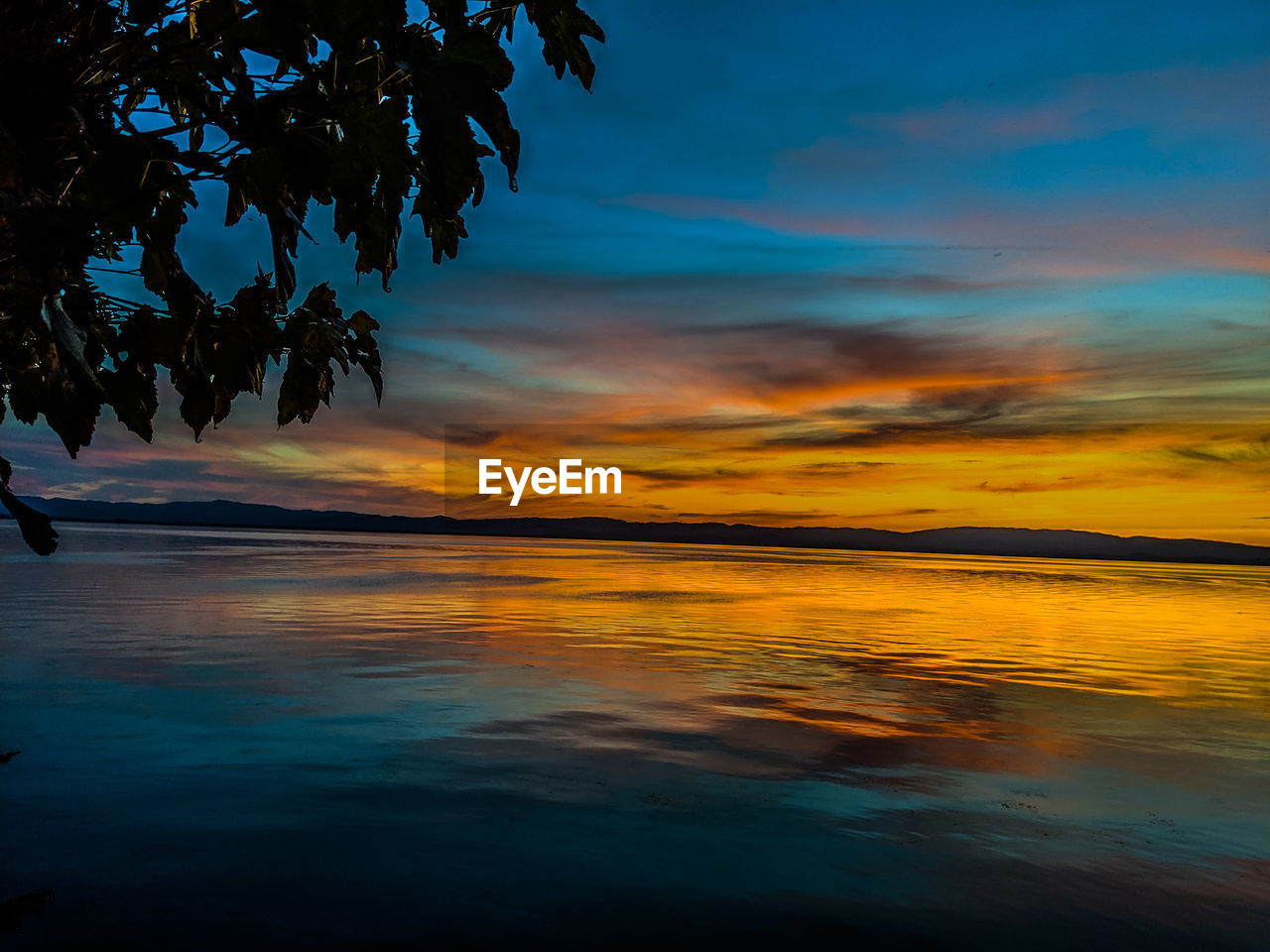 Scenic view of lake against orange sky