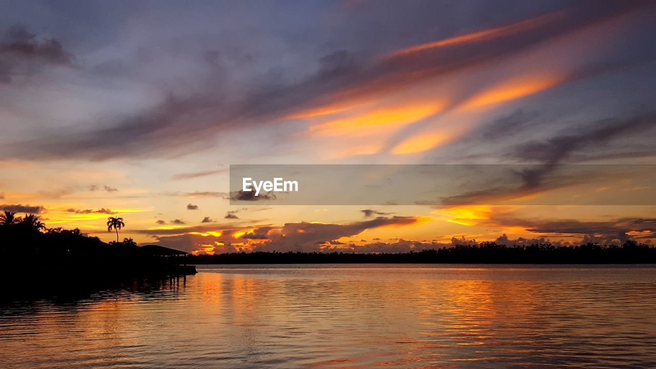 Scenic view of lake against orange sky