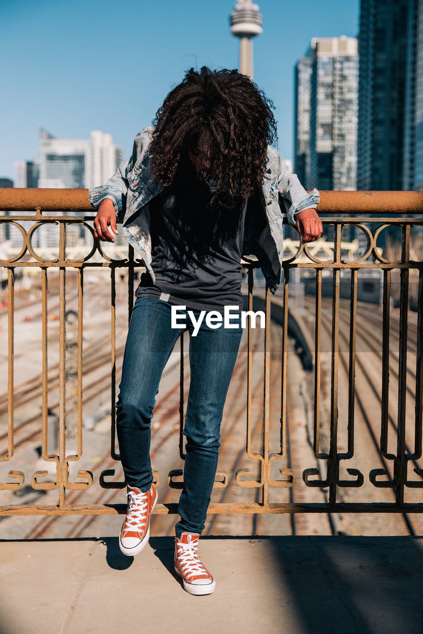 Low section of woman standing on railing