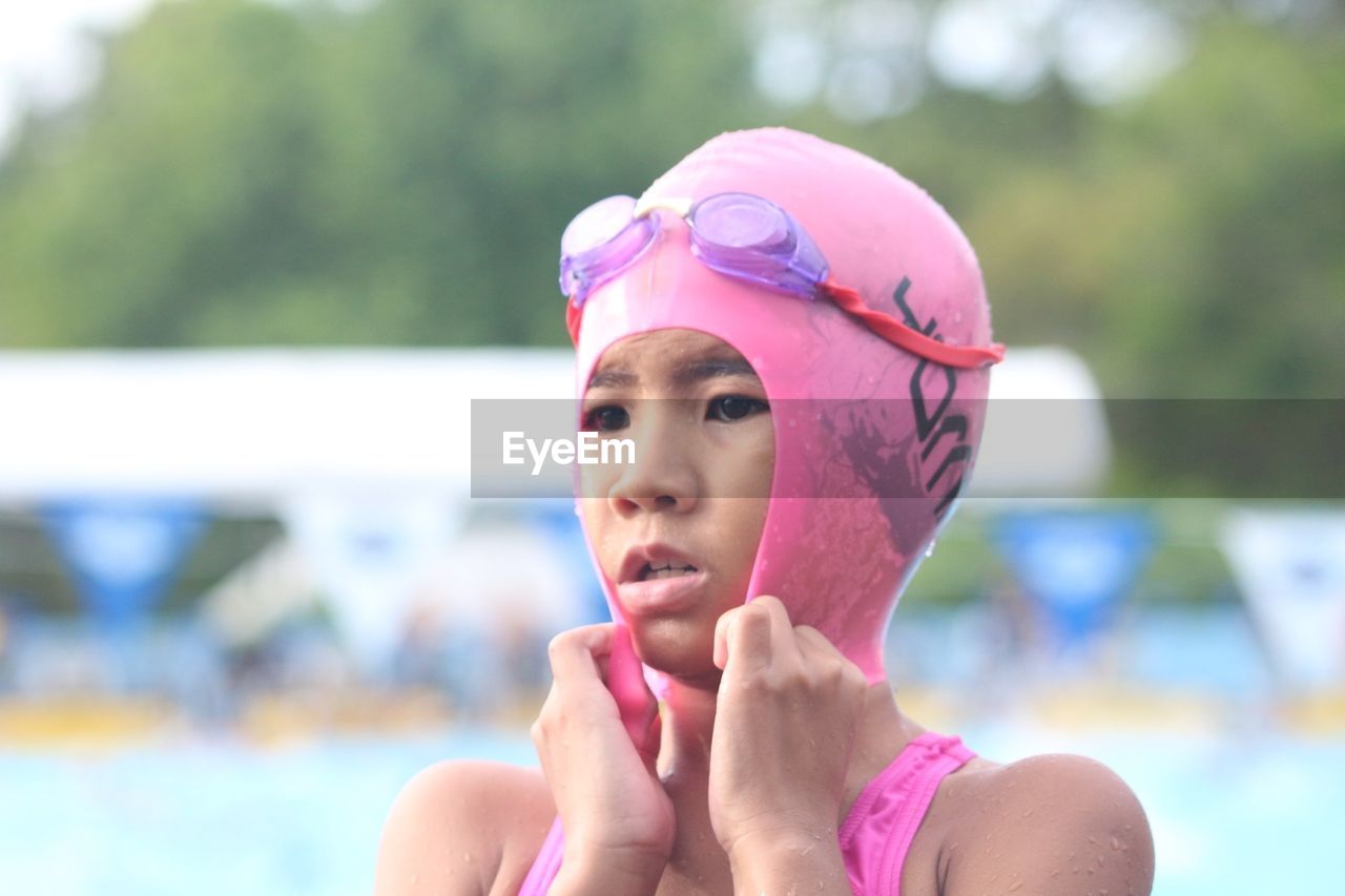 Close-up of girl wearing swimming cap at poolside