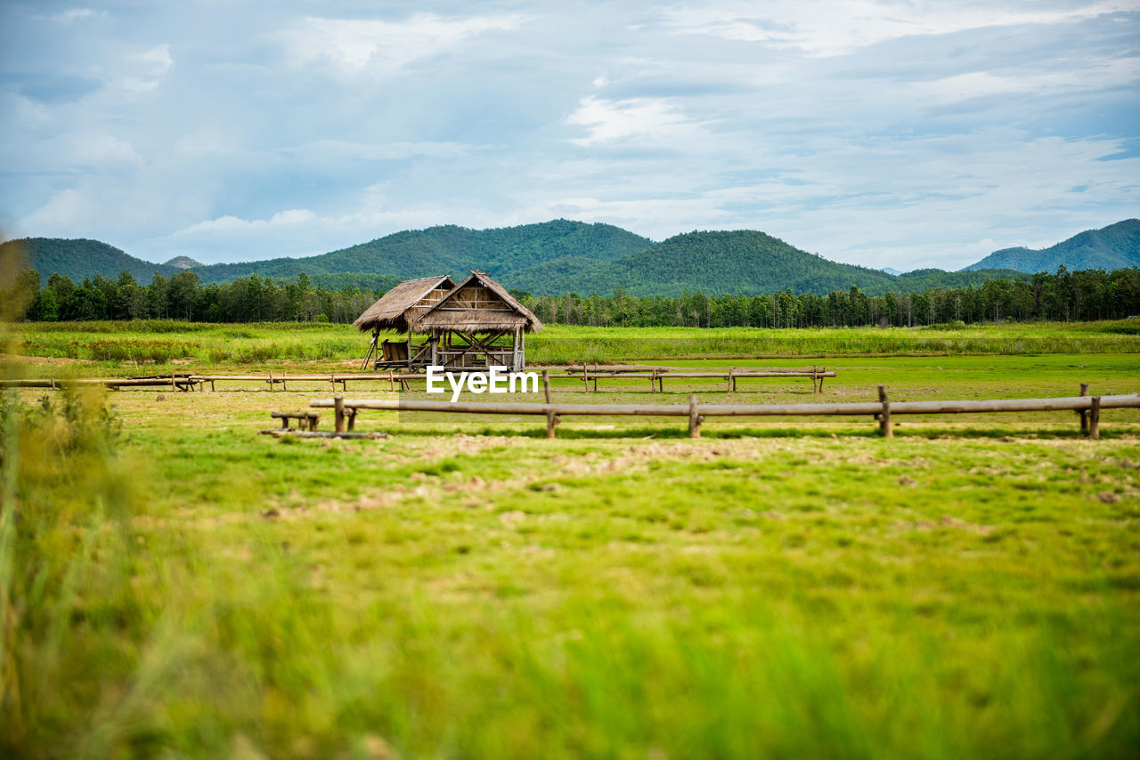 WOODEN STRUCTURE ON FIELD AGAINST SKY
