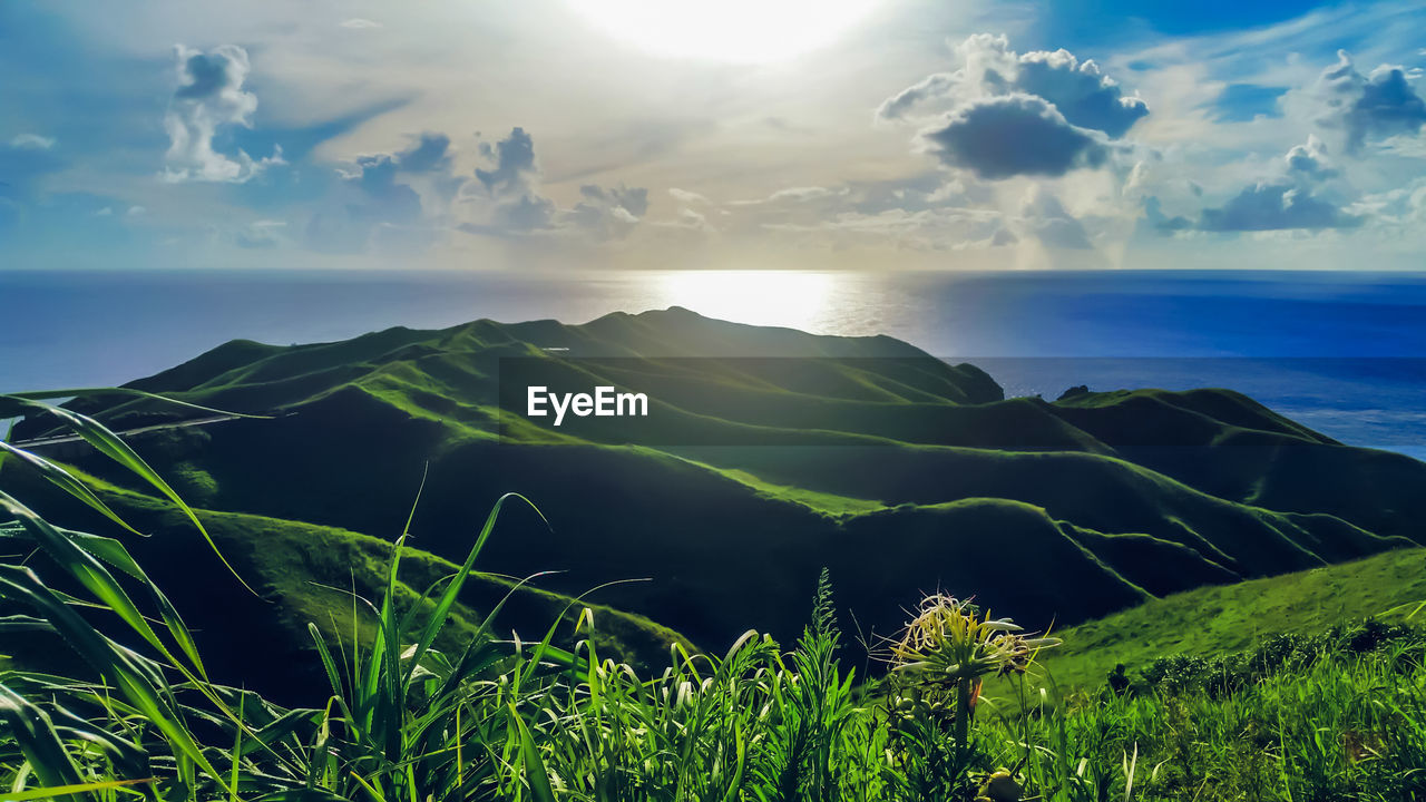 SCENIC VIEW OF SEA BY MOUNTAIN AGAINST SKY