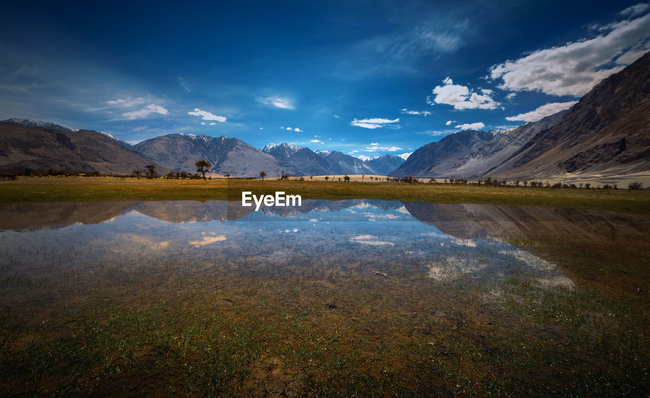 Scenic view of lake and mountains against sky