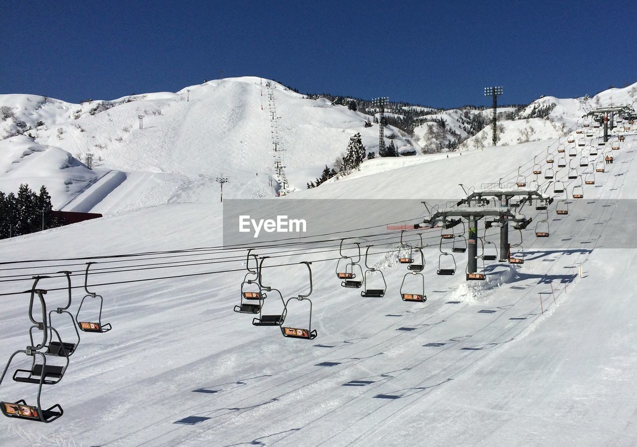 High angle view of overhead cable cars above snowcapped mountains during winter