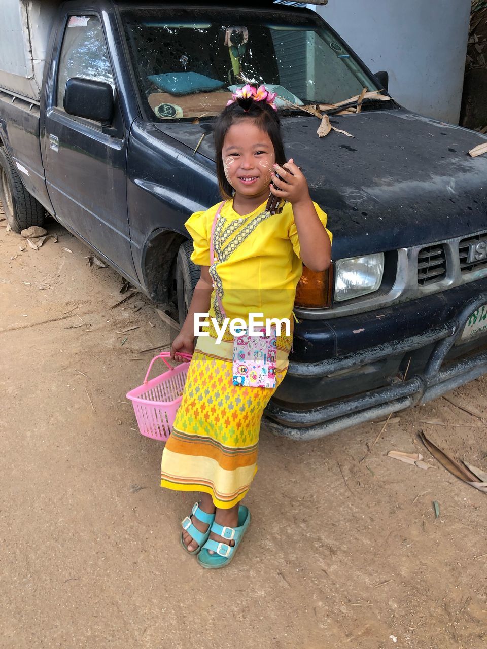 PORTRAIT OF A SMILING GIRL STANDING ON CAR