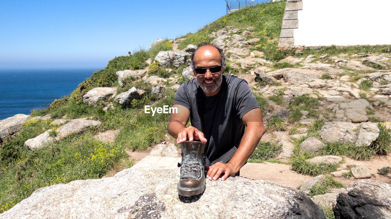 Man keeping boot on rock at mountain