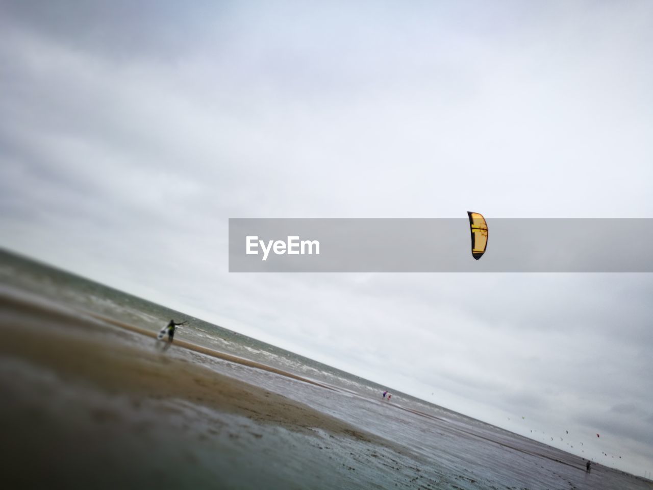 PERSON PARAGLIDING OVER BEACH