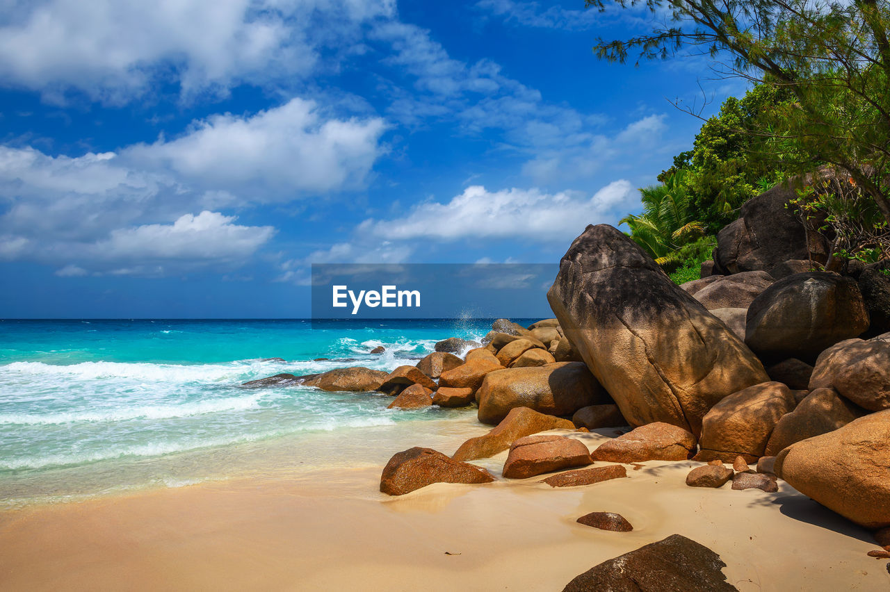 rocks on beach against sky