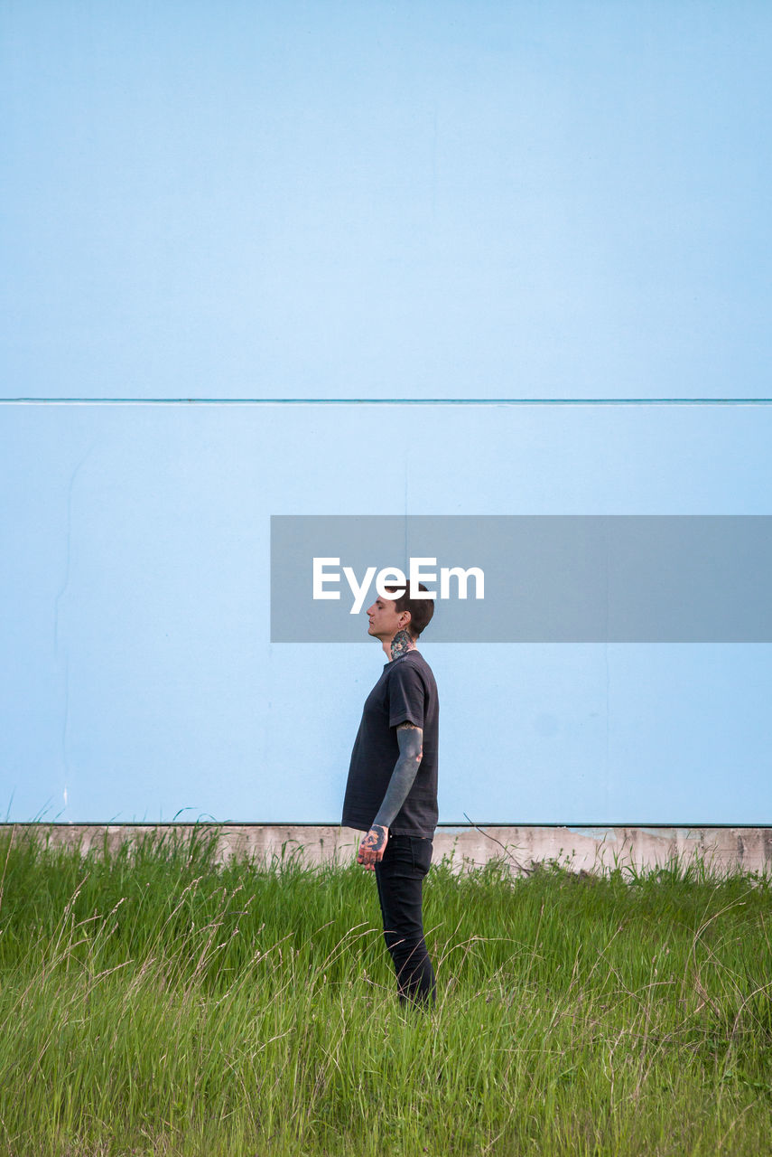 Side view of young man standing on field