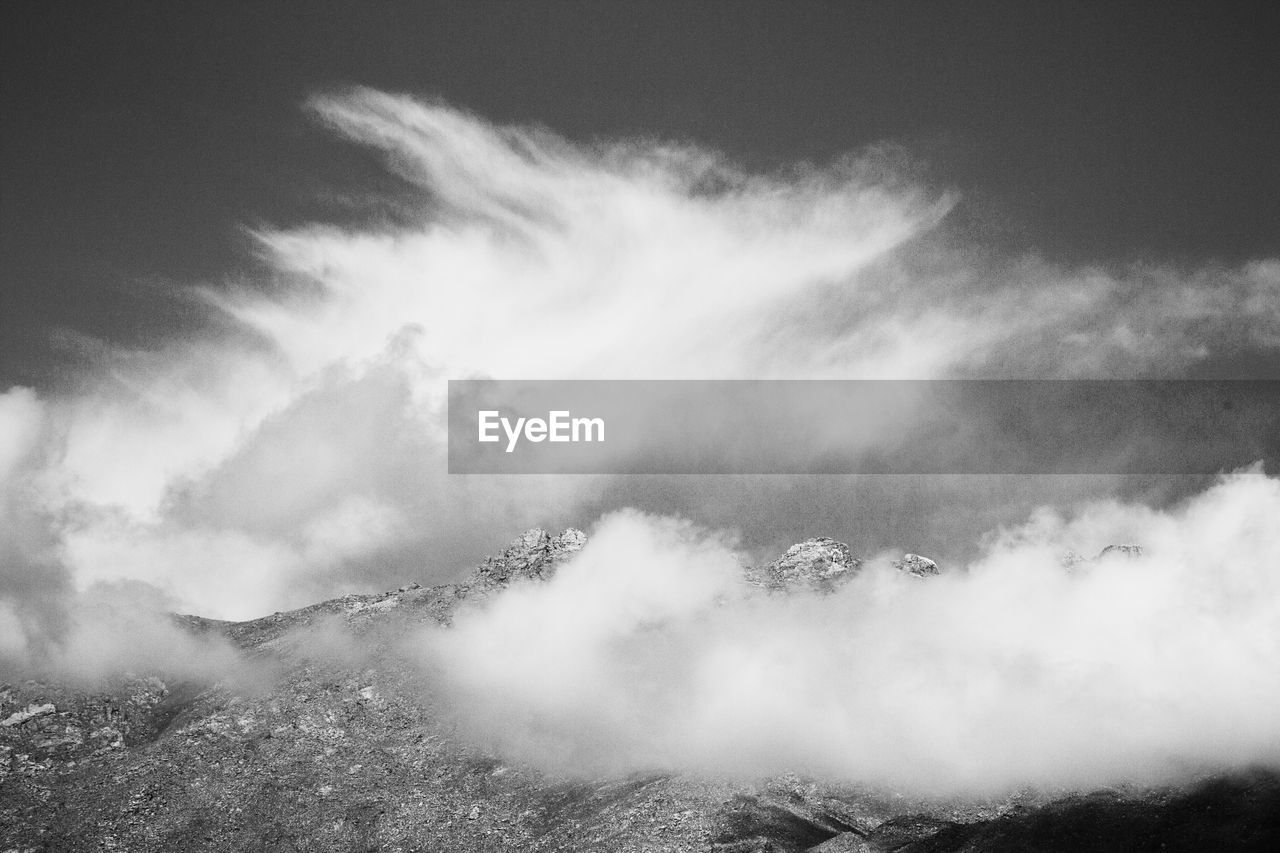 Scenic view of mountains against sky in foggy weather