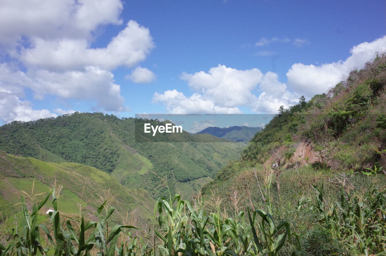 SCENIC VIEW OF MOUNTAINS AGAINST CLOUDY SKY