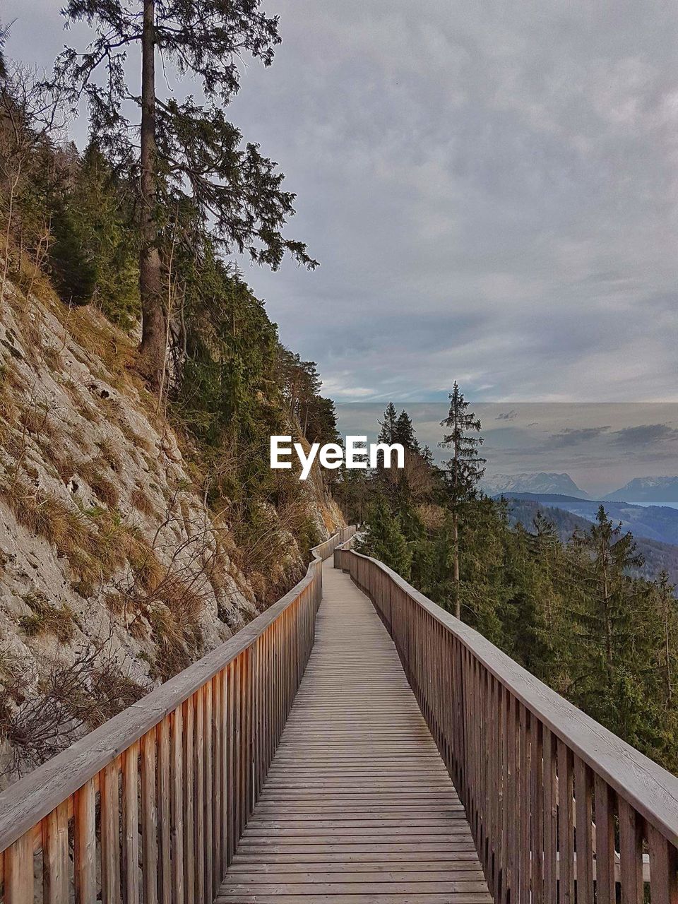 FOOTBRIDGE OVER MOUNTAIN AGAINST SKY