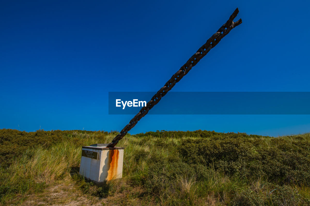 WINDMILL ON FIELD AGAINST CLEAR SKY