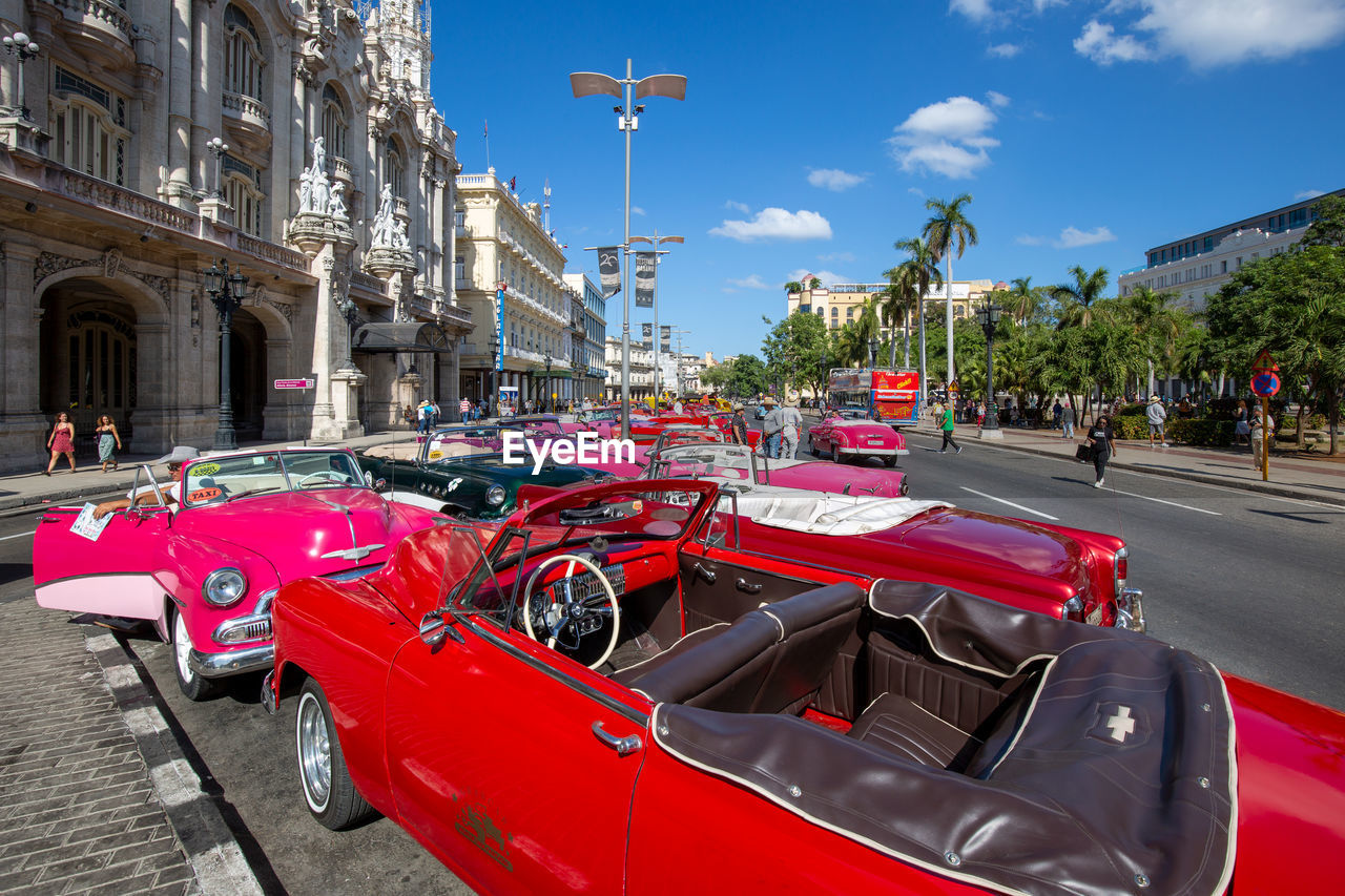 VEHICLES ON ROAD BY BUILDINGS IN CITY