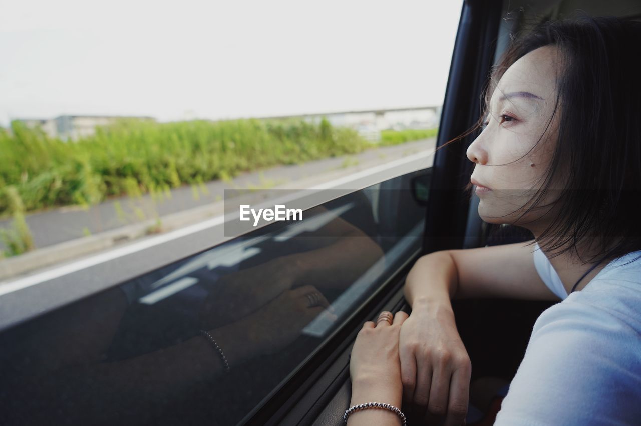 Woman looking through car window