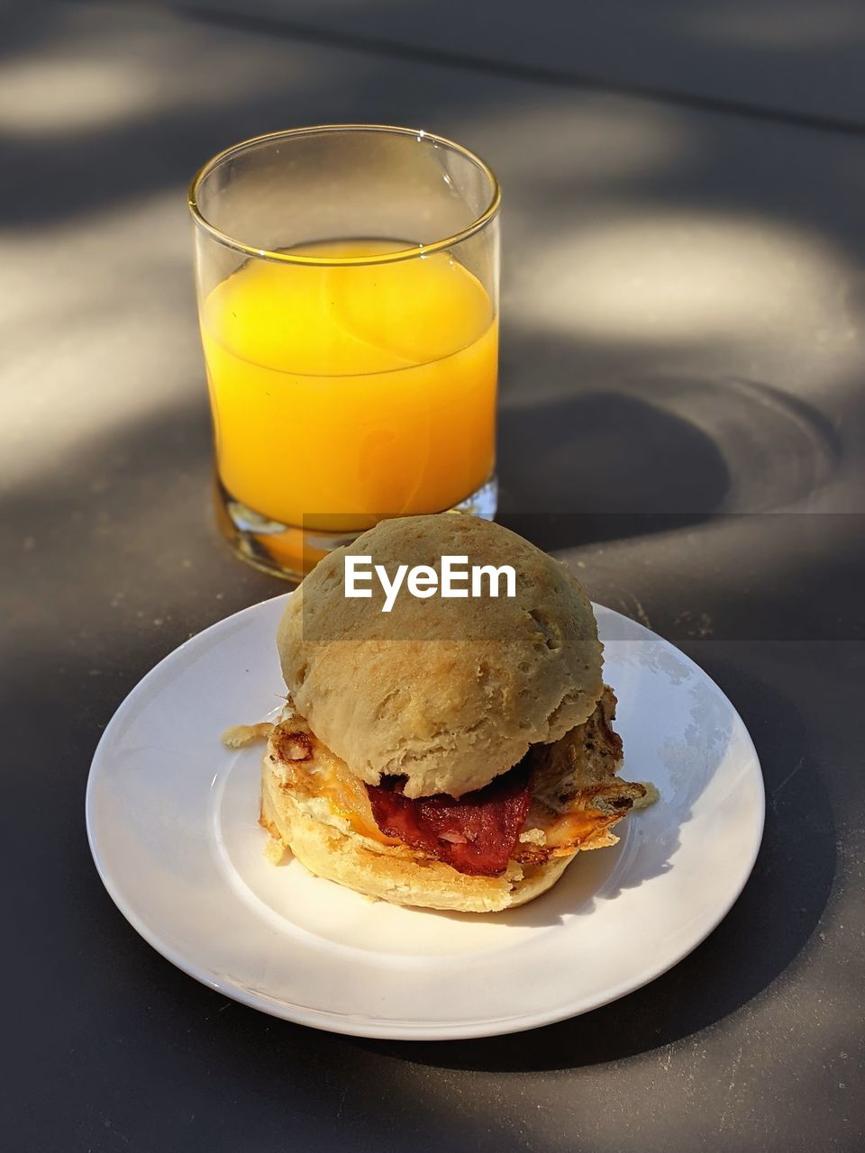 Breakfast sandwich and glass of orange juice 
