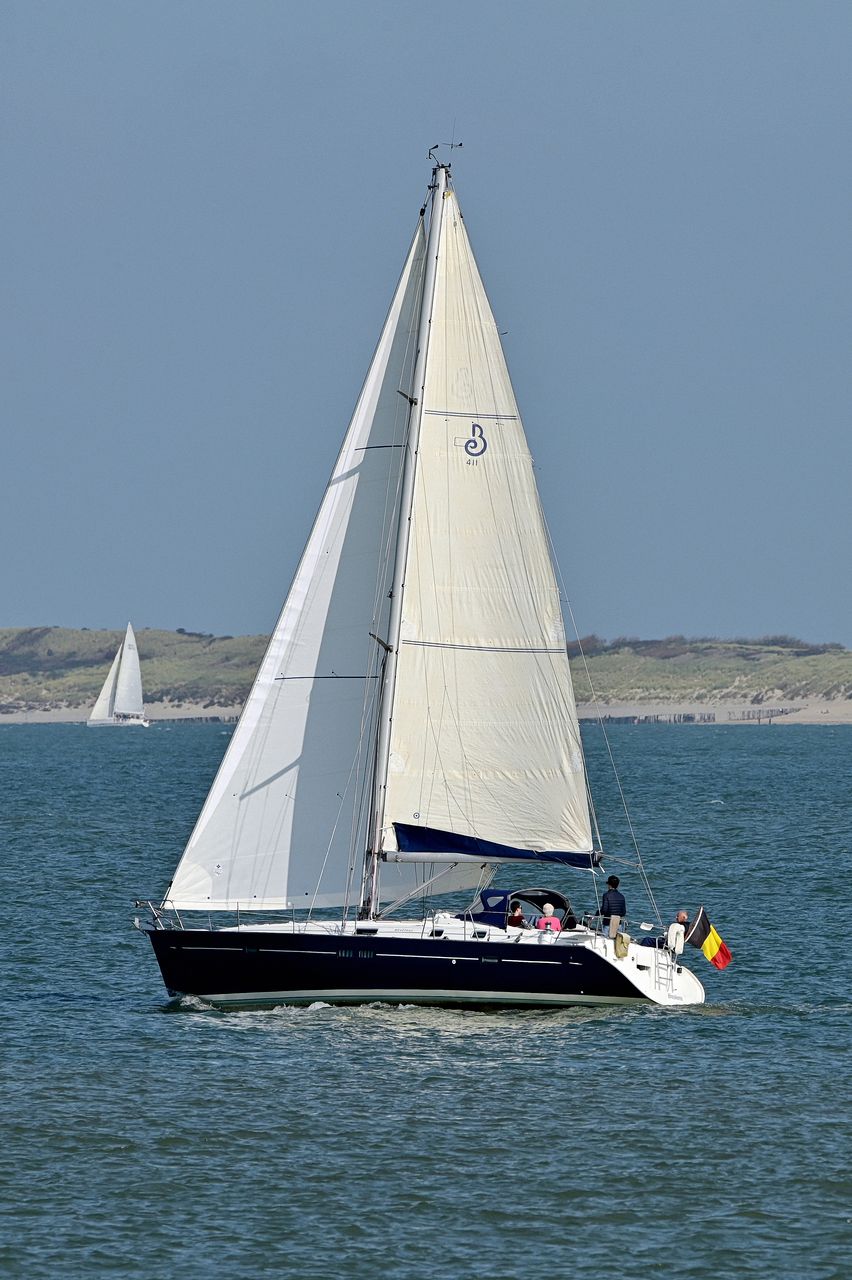 Sailboat sailing on sea against sky