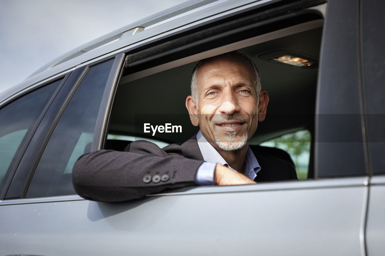 Businessman looking from window while sitting in car