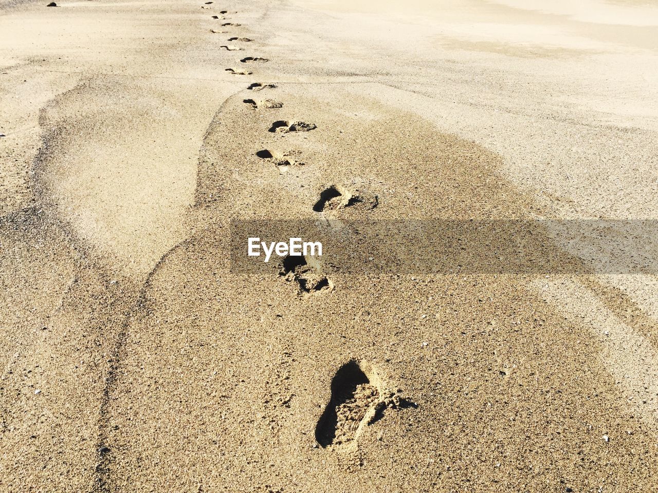 HIGH ANGLE VIEW OF FOOTPRINT ON SAND