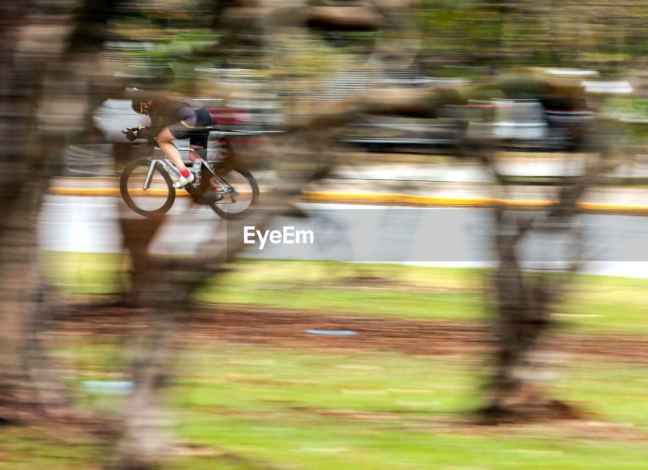 BLURRED MOTION OF MAN RIDING BICYCLE
