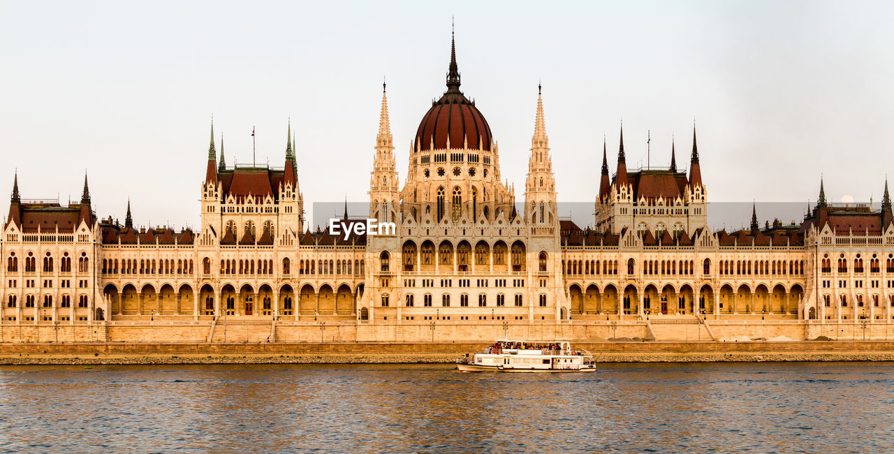 VIEW OF BUILDING AGAINST CLEAR SKY WITH WATERFRONT