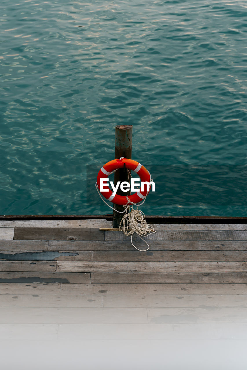 HIGH ANGLE VIEW OF RED TIED TO PIER