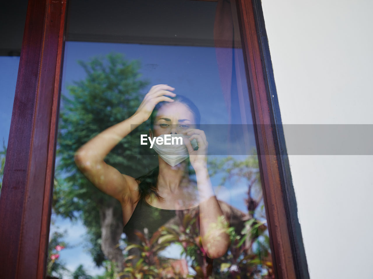 Portrait of young woman drinking glass window