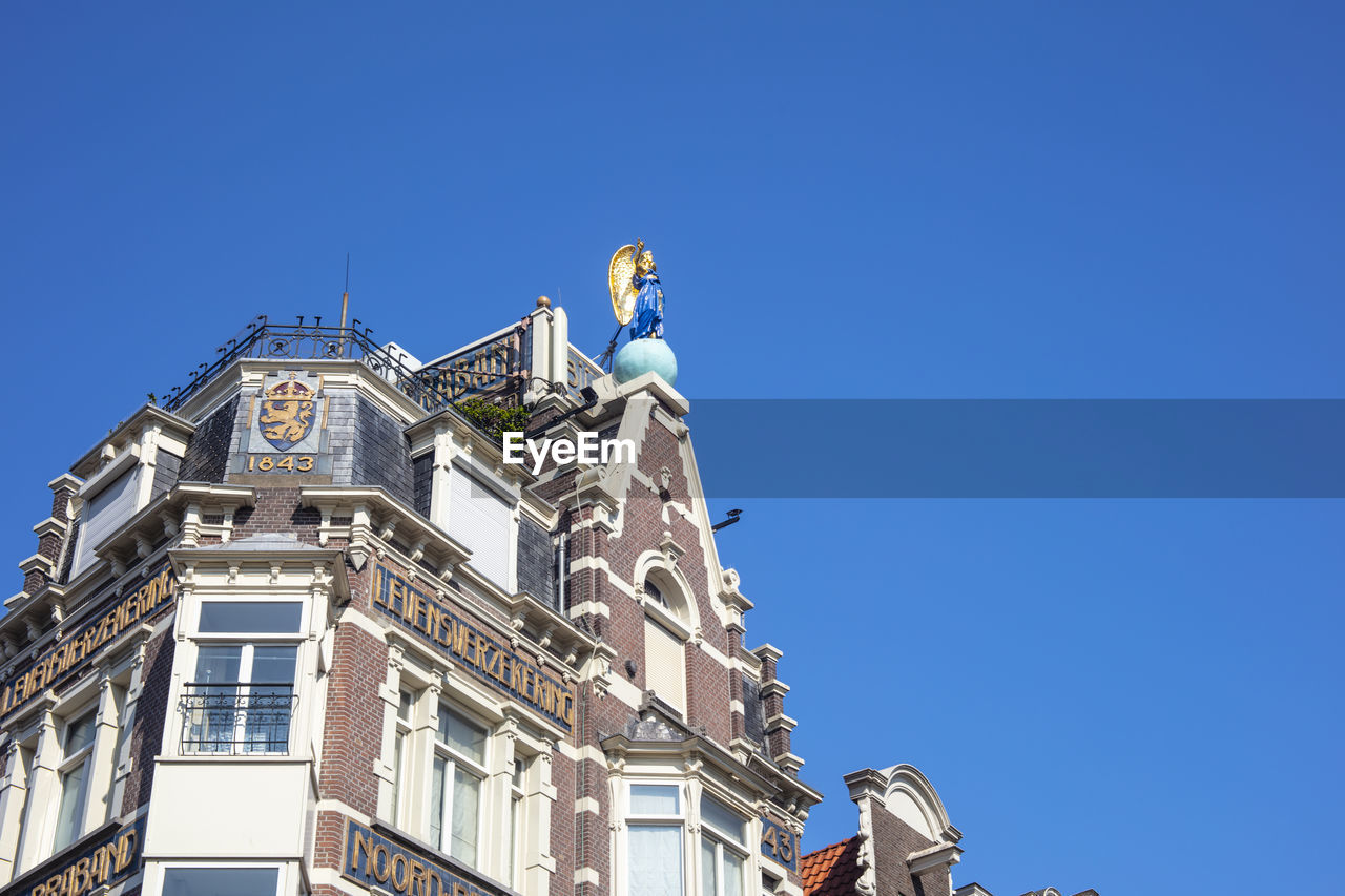 LOW ANGLE VIEW OF BUILDING AGAINST BLUE SKY