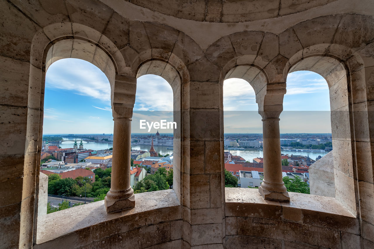 BUILDINGS SEEN THROUGH ARCH WINDOW OF COLONNADE